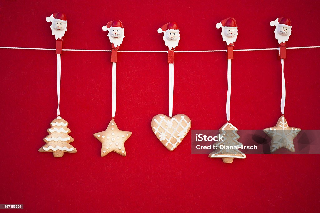 Hanging Christmas cookies Five Christmas cookie ornaments hanging in front of red non woven fabric background Arrangement Stock Photo