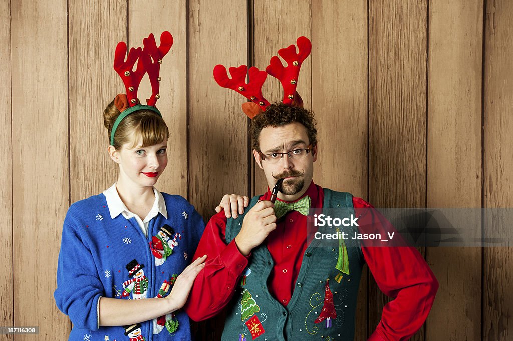 Tacky Christmas Couple Tacky Christmas couple wearing sweaters and reindeer antlers 1980-1989 Stock Photo