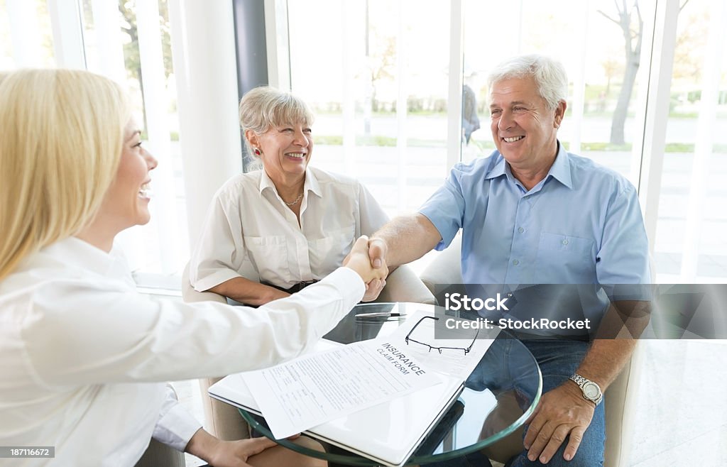 Senior feliz pareja mano con agitación agente de seguros - Foto de stock de Banco - Edificio financiero libre de derechos