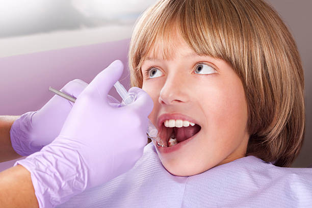 istock Young boy getting needle at the dentist office 187116773