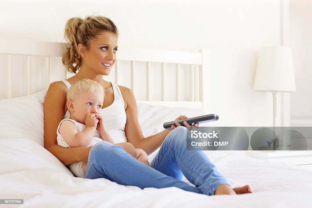 Szczęśliwa Matka i dziecko oglądając telewizor w sypialni - Zbiór zdjęć royalty-free (Jeden rodzic)