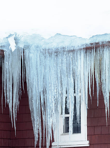 istock Winter Ice Dam and Icicles Forming on Roof Gutter 187117910