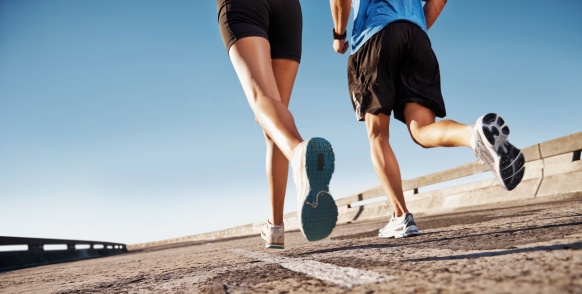 Man and woman running on a street with copyspace