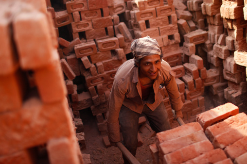 AN Indian labourer arranges briks at a brick kiln outside of Delhi