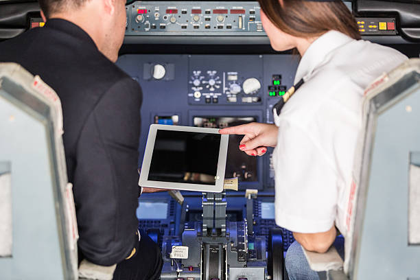 Pilot and Copilot Checking Flight Information on Digital Tablet Pilot and Copilot Checking Flight Information on Digital Tablet throttle photos stock pictures, royalty-free photos & images