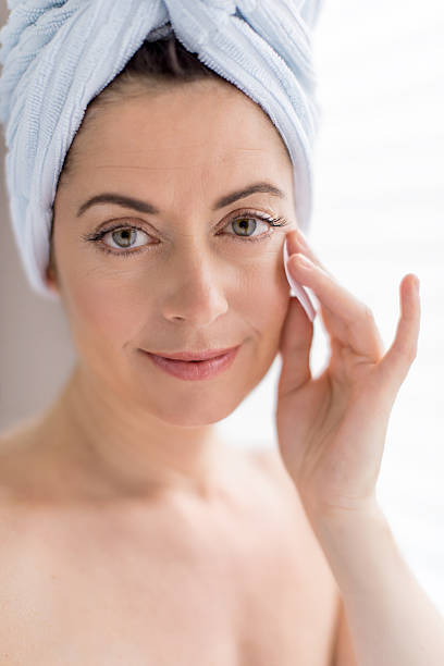 istock attractive woman in her forties removing make up 187120533