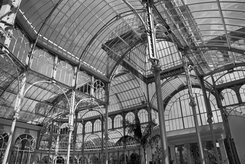 Black and white Inside view of the Crystal Palace (Palacio de Cristal), a glass an meta structure located in Madrid's Buen Retiro Park. Designed by architect Ricardo Velázquez Bosco, it was built in 1887 to exhibit flora and fauna from the Philippines.