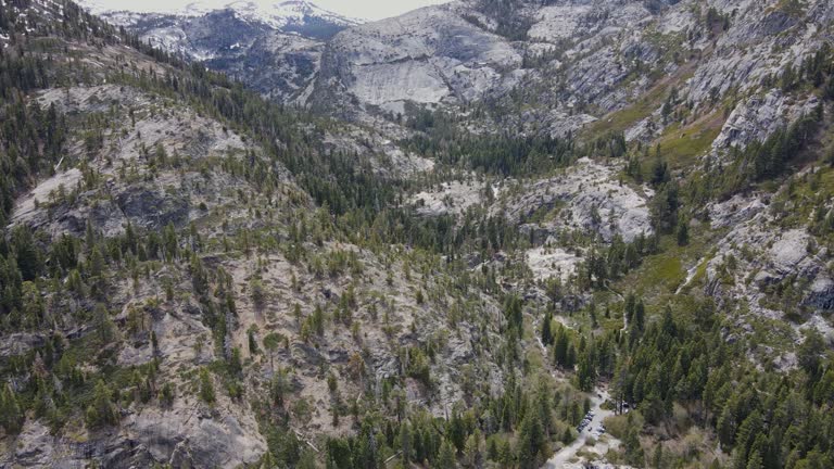 A 4K drone shot of Eagle Falls, a waterfall that runs into Emerald Bay, on Lake Tahoe, California. The camera begins facing down at the bay, then slowly pans up the falls, and the mountains behind it.