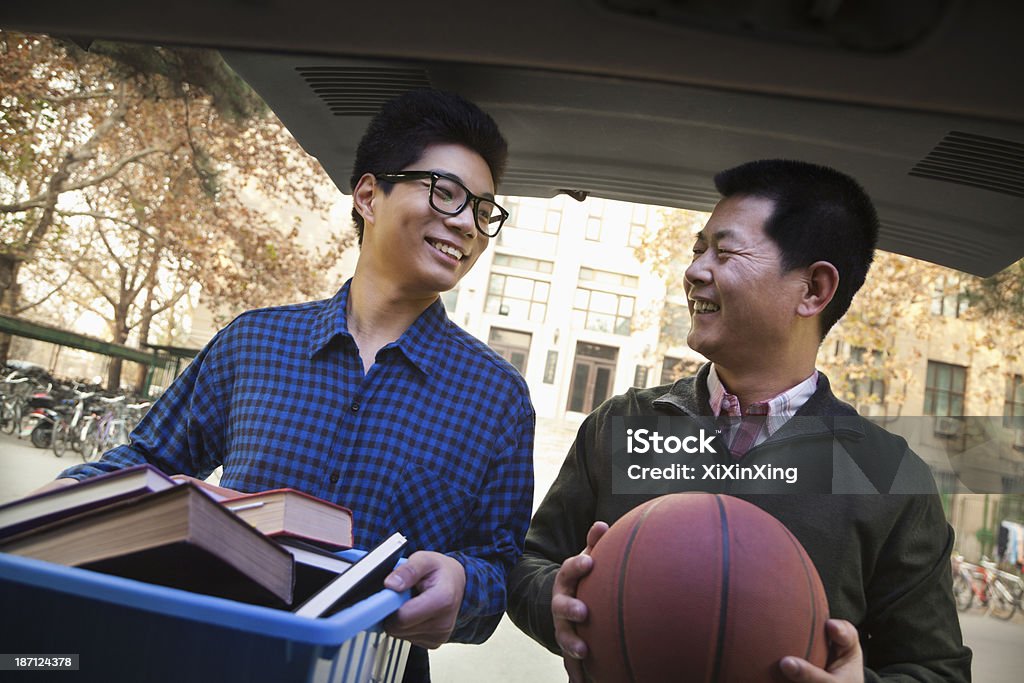 Padre E figli disimballaggio auto davanti edificio residenziale per studenti - Foto stock royalty-free di Residenza universitaria