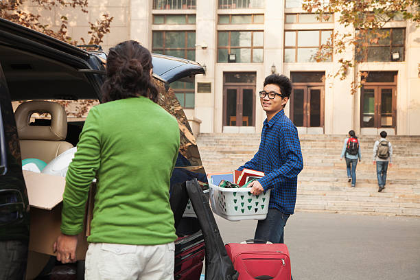 jovem movendo em dormitory no campus universitário - chinese ethnicity student china asian ethnicity imagens e fotografias de stock