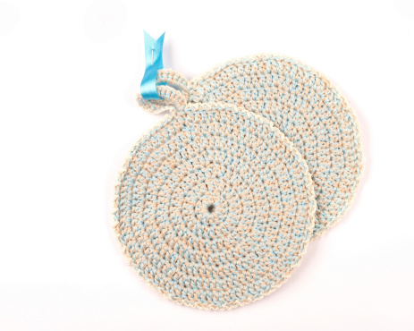 Blue and gray round crocheted pot holder isolated on white.