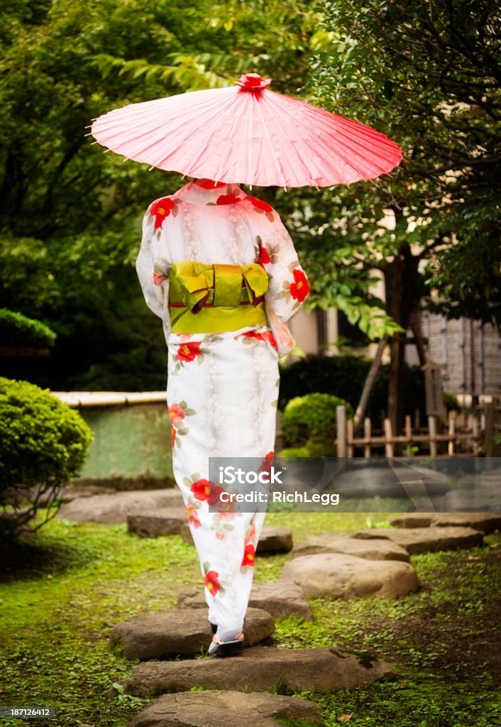 Japanese Woman A beautiful Japanese woman walking on a rock path. Kimono Stock Photo