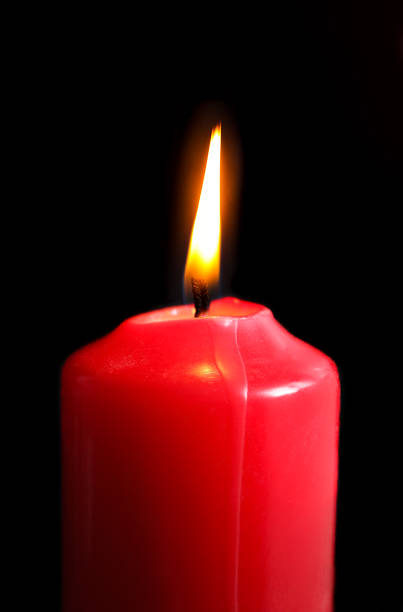 istock Red candle on black background. Christmas candle on dark background side closeup view 1871283510