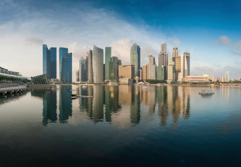 The futuristic skyscrapers and crowded Central Business District of downtown Singapore reflecting in the tranquil waters of Marina Bay. ProPhoto RGB profile for maximum color fidelity and gamut.