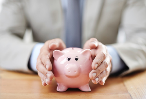 Cropped image of a businessman's hands covering his piggybank