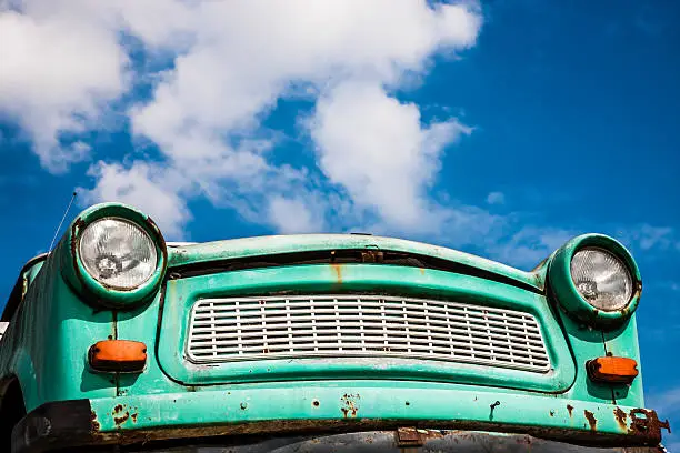 old German car, front low angle view against blue sky