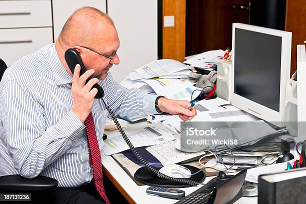 Genialidad De Oficina En Su Desordenado Escritorio Foto de stock y más banco de imágenes de Desordenado - Desordenado, Escritorio, Oficina