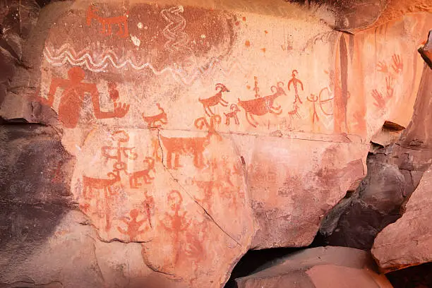 Pictograph rock art at the Palatki site in Loy Canyon, Arizona.  Most of the artwork is attributed to the Sinagua, who inhabited the area between 650AD and 1200AD, but in some cases artwork from other time periods is interspersed and overlayed with the Sinaguan.  More primitive etchings date as far back as 6000 years, while a few markings were made by ancestral Apache more recently (confirmed by tribal elders).  Pictographs are painted images, whereas petroglyphs are etchings performed by abrading the rock with the edge of another.  Pictographs at this site are typically in white, red and black, or kaolin, hematite and charcoal.  Archeologists believe that much of the art at the Palatki site relates to the dreamstate imagery of ancient Shamans.  This image reflects the typical flat, protected rock face alcove on which Sinaguan art can be found, with numerous depictions of animals and references to life's journey on the Earth.  Yavapai County, Arizona, 2013.