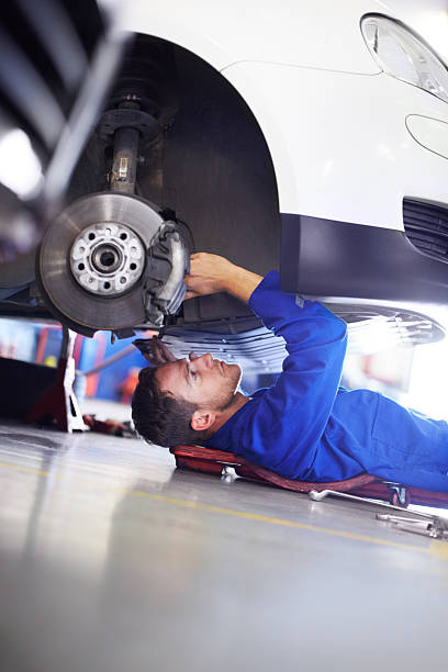 I love to fix cars A car mechanic working on the underside of a car mechanic working under car stock pictures, royalty-free photos & images