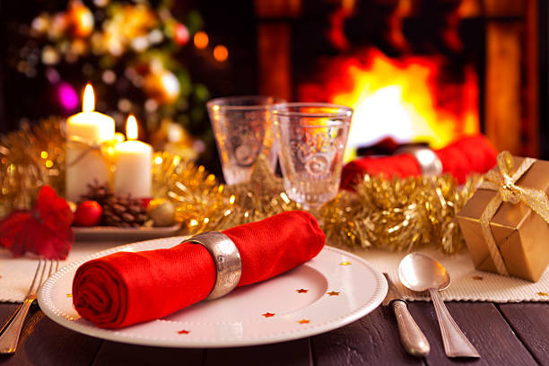Christmas table setting with a Christmas tree and a fireplace in the background.
