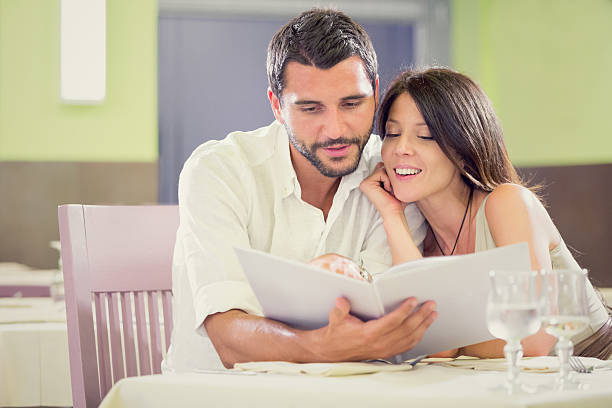 istock Young romantic couple at restaurant reading menu 187139193