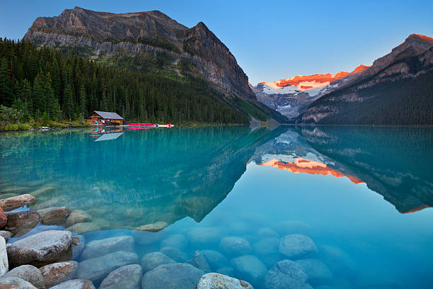 lake louise, banff national park, kanada bei sonnenaufgang - alpenglühen stock-fotos und bilder