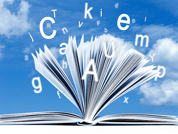 istock Opened book, flying letters against blue, cloudy sky background 187141142