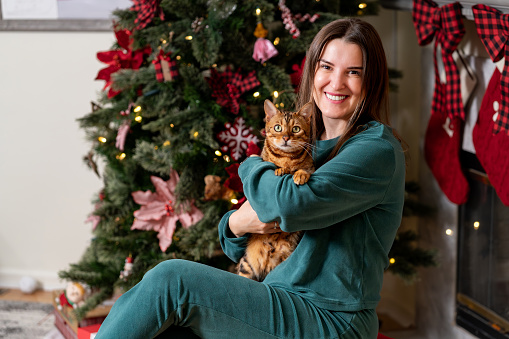 Latin woman enjoying Christmas with her cat at home