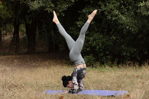 Strong female doing handstand while practice body balance.