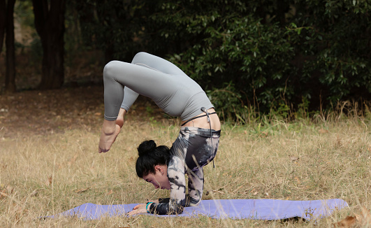 Strong female doing handstand while practice body balance.
