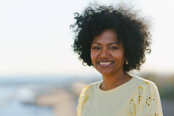 istock African woman smiling at camera standing outdoors during sunset 1871463501