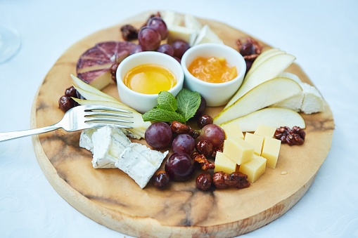 Different assortment of cheese on a plate. Menus for restaurants and cafes. Decoration with various ingredients.