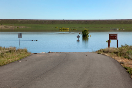 Just east of the town of Morrison, flood waters of Bear Creek inundate roads, trees, signs and buildings in Lakewood, Colorado's Bear Creek Lake Park after days of heavy mid-September rains. The reservoir dam stands in the distance.