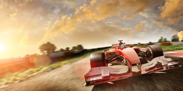 Image of racing car with intentional motion blur driving fast on racetrack at sunset