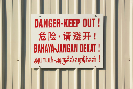 A multilingual (English, Chinese, Malay, Tamil) construction warning sign in Singapore.