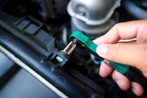 istock Car mechanic hand tighten nuts with small socket wrench 1871538325