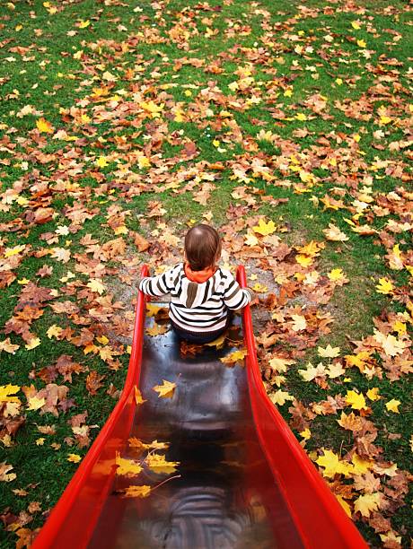 a 1 year old boy on the playground in autumn