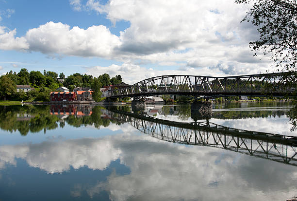 Puente y edificios reflexionando sobre un lago - foto de stock