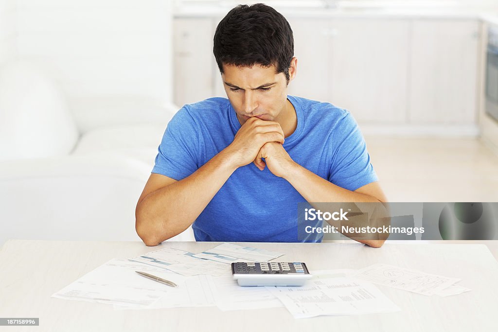 Jeune homme à la recherche dans les factures domestiques - Photo de Adulte libre de droits