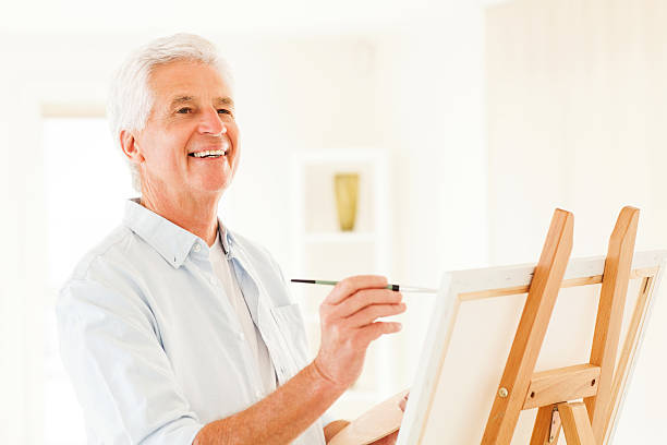 istock Senior Man Looking Up While Painting On Canvas 187159195