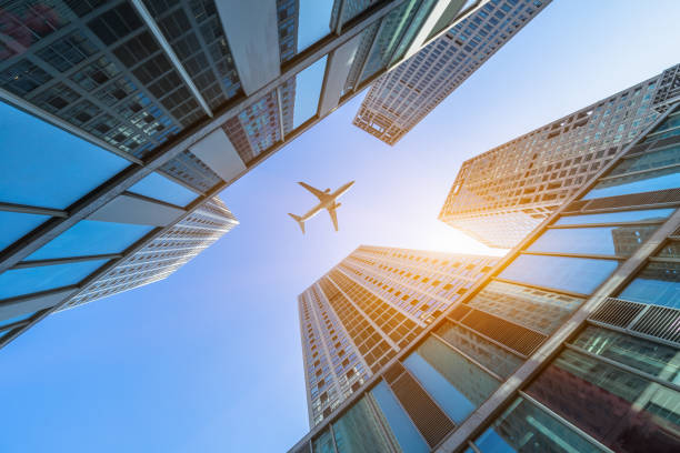 istock Tall city buildings and a plane flying overhead 1871601391