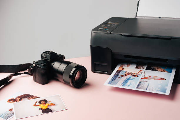 istock Printer and photo camera on table. Printing photos concept 1871601923