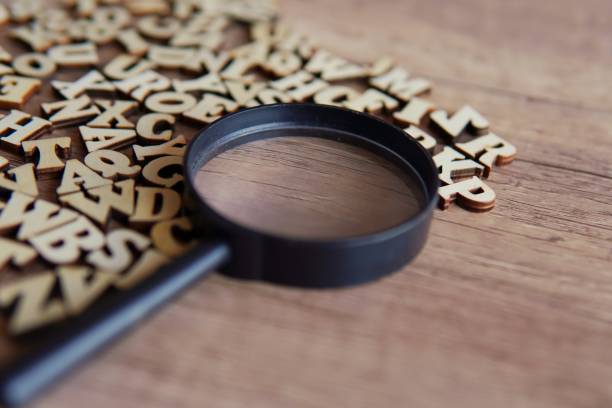 istock Magnifying glass with scattered alphabet letters on the table. 1871602442
