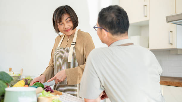 istock A husband is enjoying talking with his wife while she is cooking breakfast in the kitchen. 1871607743