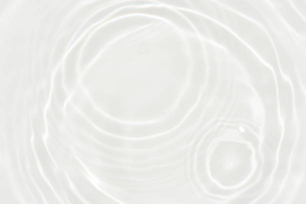 istock White water with ripples on the surface. Defocus blurred transparent white colored clear calm water surface texture with splashes and bubbles. Water waves with shining pattern texture background. 1871613481