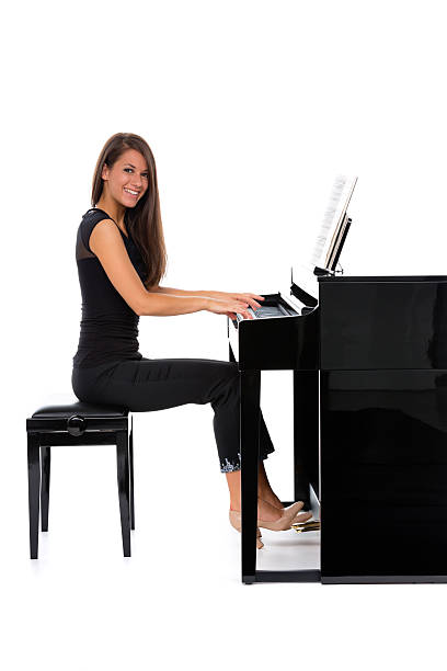 istock happy young woman playing piano 187164034
