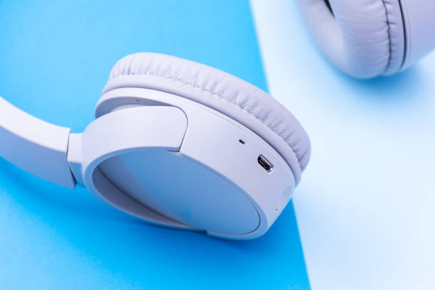 istock Close-up wireless headphones isolated on a blue background. 1871642555