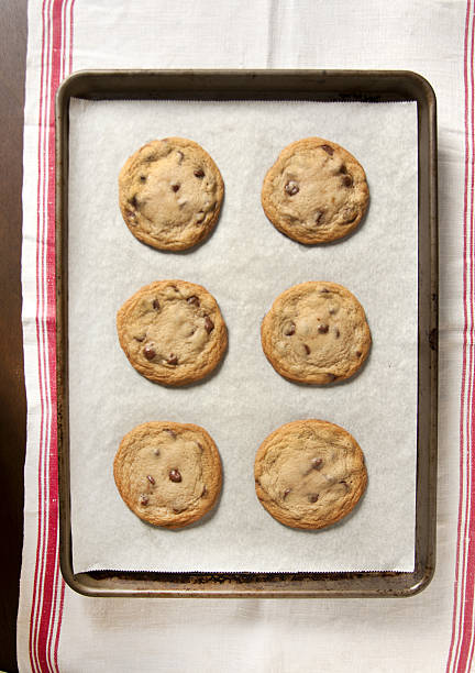chocolate chip cookies Overhead shot of six freshly baked chocolate chip cookies baking sheet stock pictures, royalty-free photos & images