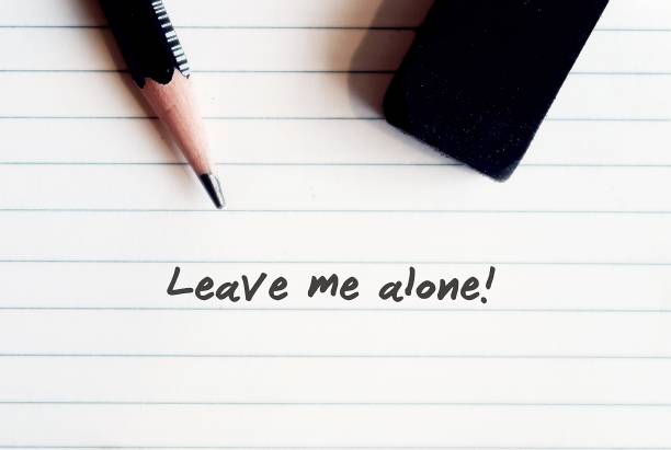 istock Pencil and rubber on lined sheet paper background with text wrotten LEAVE ME ALONE. Asking other  for private time or to stop talking / stop being near/ stop interfering. 1871658929
