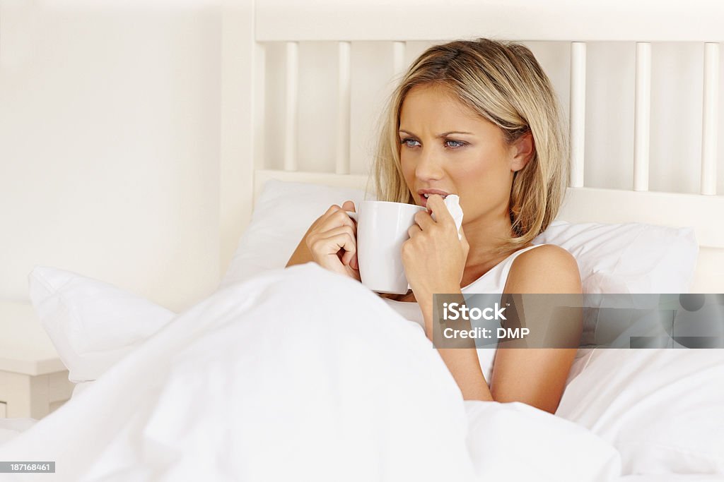 病気の若い女性のベッドがホットドリンク - 1人のロイヤリティフリーストックフォト